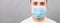 Portrait of young sick man in medical mask with Stay home word at gray cement background. Respiratory protection. Coronavirus self