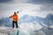 Portrait of a young skier with skis on his shoulder. It stands high in the mountains on a glacier against the backdrop