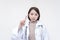 Portrait of a young and skilled doctor, medical student, intern posing with one finger up, scolding someone. Isolated on a white