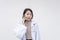 Portrait of a young and skilled doctor, medical student, intern talking to someone on the phone. Isolated on a white background
