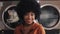 Portrait of young smiling African American woman standing in the self-service public laundry.