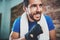 Portrait of Young smiling athlete tying black boxing bandages.Boxer man prepairing before kickboxing training. Blurred