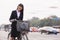 Portrait of young smiling businesswoman riding a bicycle on the street in Beijing, looking at camera