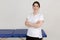 Portrait of young smiling confident masseuse therapist doctor woman wearing white uniform, standing with crossed hands.