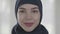 Portrait of a young smiling eastern woman in the modern Muslim clothes and beautiful black headdress close up. Young