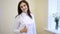 Portrait of young smiling female brunette Doctor-cosmetologist shows thumb