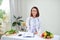 Portrait of young smiling female nutritionist in the consultation room. Dietitian working on diet plan