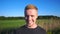 Portrait of young smiling man standing at rural environment. Handsome guy with beard looking into camera with beautiful