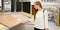 Portrait of young smiling woman choosing wood laminated flooring in shop