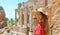 Portrait of young smiling woman with hat in famous Taormina Greek Theatre, Sicily, Italy