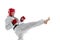 Portrait of young sportive man, taekwondo fighter wearing white dobok, helmet and gloves practicing isolated over white