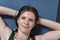 Portrait of young sports girl resting after training on yoga mat putting hands behind head. Top View. Close up