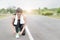 Portrait of young sports girl tying shoelaces on the road.