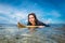 portrait of young sportswoman in wetsuit on surfing board in ocean at Nusa dua Beach