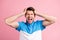 Portrait of young stressed annoyed man screaming have headache suffering isolated on pink color background
