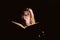 portrait of young student reading a book over black background