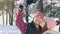 Portrait of a young stylish couple doing selfie in a red shirt and hat, in a winter park sun