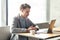 Portrait of young successful serious businessman working on computer sitting in office