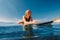 Portrait of young surf girl in ocean during surfing. Beauty surfer woman lies on surfboard