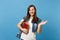 Portrait of young surprised lovely woman student with backpack pointing hand aside holding school books ready to learn