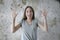 Portrait of young surprised woman with opened mouth standing with open palms