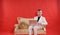 Portrait of a young teen man wearing white office suit and sitting on the golden luxury sofa on red background. he works on the la
