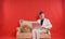 Portrait of a young teen man wearing white office suit and sitting on the golden luxury sofa on red background. he works on the la