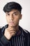 Portrait of young teenager resting chin on fist, clean shave and wearing black jacket against white background