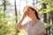 Portrait of a young tired woman in a straw hat, wiping sweat from her forehead. Summer and hot. The concept of protection from