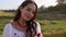 Portrait of young Ukrainian smiling woman in traditional national embroidered shirt and necklace on meadow