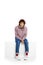 Portrait of young unhappy boy sitting over white background. Looking sad, thoughtful and lonely