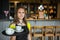 Portrait young waitress standing in cafe. girl the waiter holds in bunches a tray with utensils