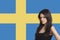 Portrait of young woman against Swedish flag