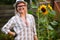 Portrait of young woman agronomist posing near sunflower