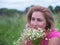 Portrait of young woman with bouquet of daisies.