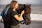 Portrait of young woman and brown horse. Young Caucasian woman hugging horse. Romantic concept. Love to animals. Nature concept.