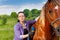 Portrait of young woman brushing beautiful horse