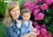 Portrait of the young woman with the child about the blossoming hydrangea
