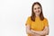 Portrait of young woman with confident smile, relaxed professional pose, wearing yellow t-shirt of company, cross arms