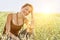 Portrait of young woman crouching in field of grass