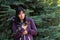 Portrait of a young woman with a feathered friend speckled chicken against a blue spruce