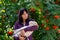 Portrait of a young woman with a feathered friend white goose against rowan with orange berries