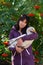 Portrait of a young woman with a feathered friend white goose against rowan with orange berries