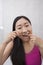 Portrait of young woman flossing her teeth in bathroom