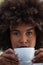 Portrait of young woman with frizzy hair holding coffee cup