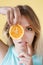 Portrait of a young woman getting funny with orange.