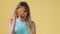 Portrait of a young woman getting funny with orange. yellow background with place for text