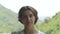 Portrait young woman green mountain landscape at summer day. Face girl looking into camera on mountain covered green