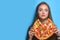 Portrait of young woman holding and eating pizza. Creative idea concept, funny mugshot with pizza