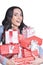 Portrait of young woman holding pile of present boxes